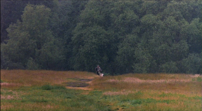 A knight charging into battle, far across an open field.