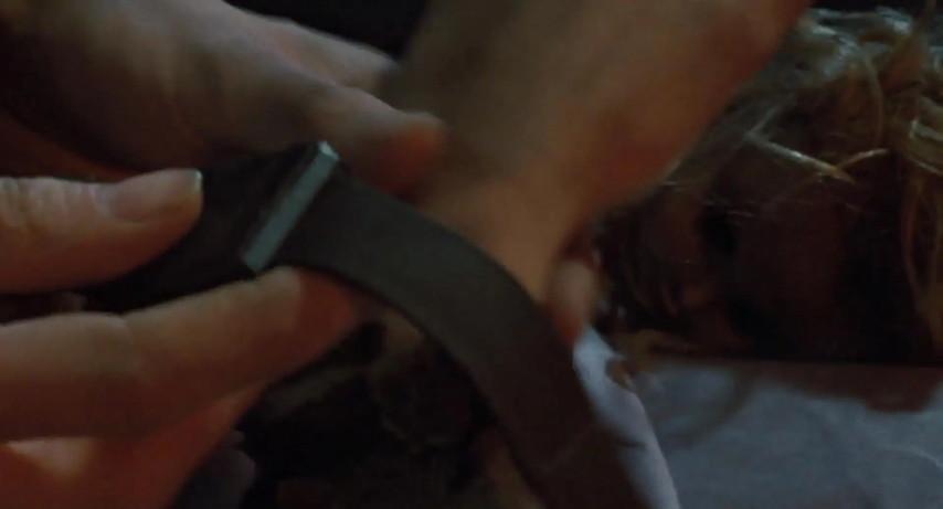 An image from the movie "Aliens". Ripley puts a tracking bracelet on Newt's wrist.