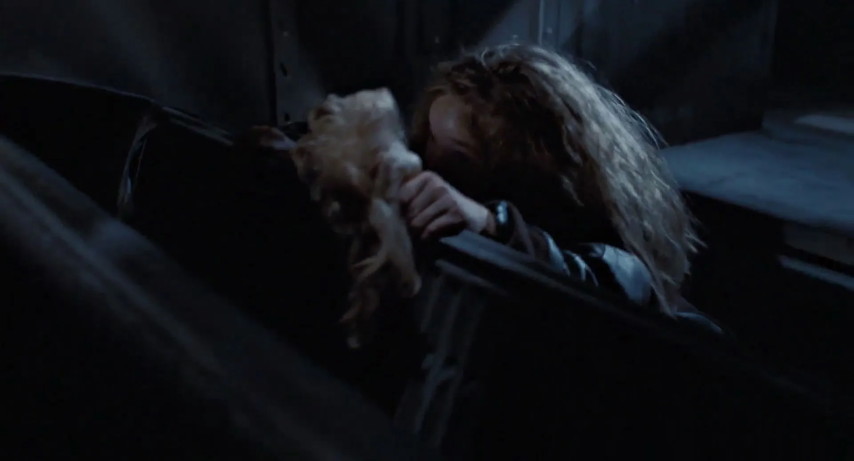 An image from the movie "Aliens". Newt (wearing a tracking bracelet on her left wrist) slips through a hole in the floor.