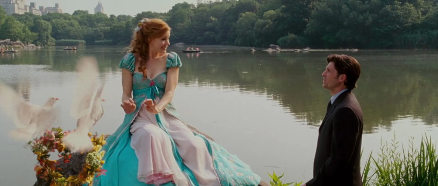 An image from the move "Enchanted". Robert and Giselle sit by a lake in Central Park. Doves carry a wreath of flowers.
