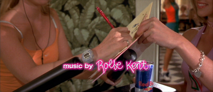 An image from the movie "Legally BLonde". A sorority sister holds a greeting card for another sister to sign.